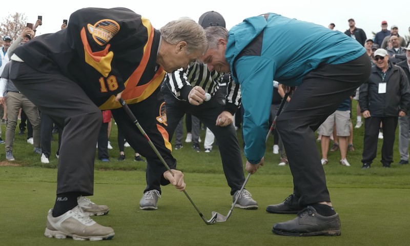 Two golfers pretending to play hockey
